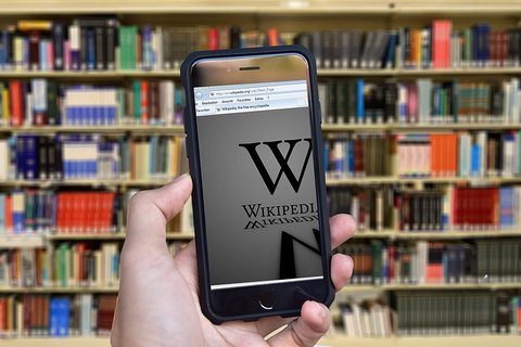 mobile with wikipedia against library backdrop